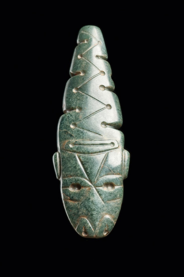 Costa Rican Jade Duality Pendant, Serpent and Human, 500-1000 CE: Pre-Columbian, Costa Rica, ca. 500–1000 CE. A blue-green jade pendant carved as a serpent, its tapering body scored with an incised zigzag punctuated by drilled dots and stepped notches along bo
