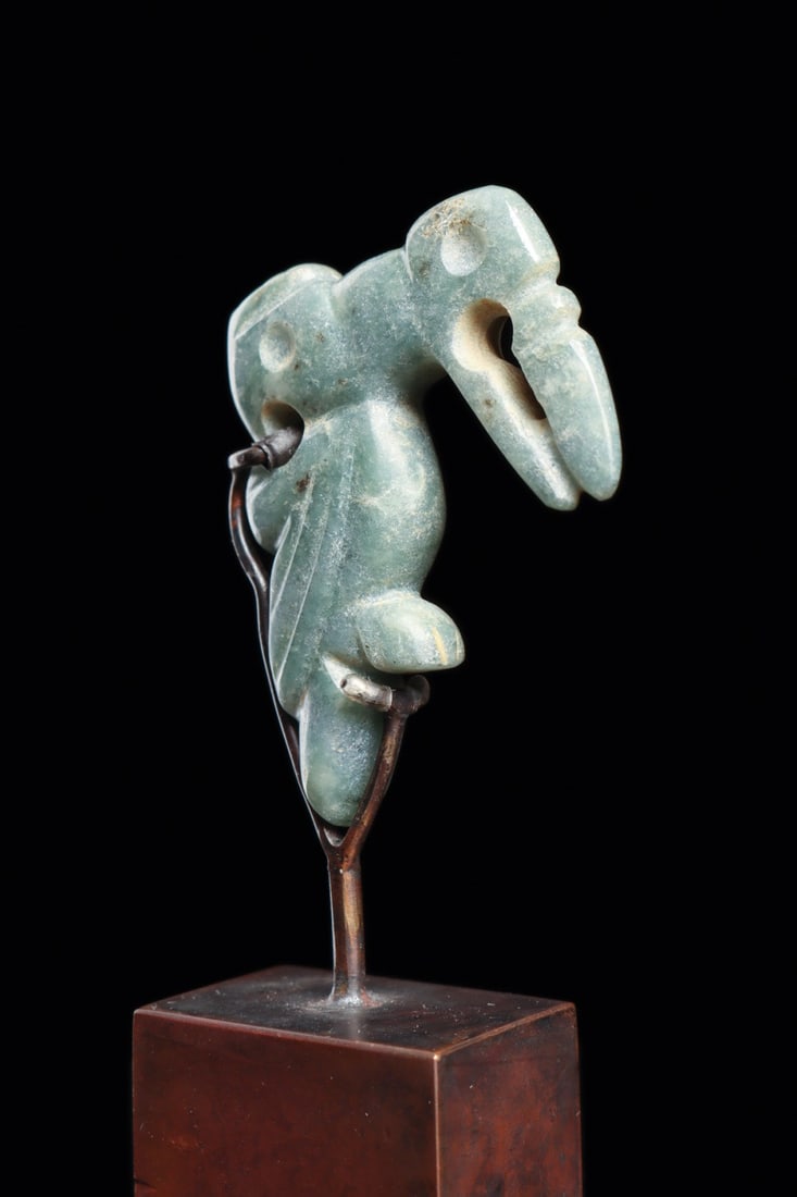 Costa Rica Jade Double-Headed Avian Pendant, Ca. 500-1000 CE: Pre-Columbian, Costa Rica, ca. 500–1000 CE. A miniature pendant carved from blue-green jade, worked in the round and finished on both faces. The subject is a perched bird, wings folded against a