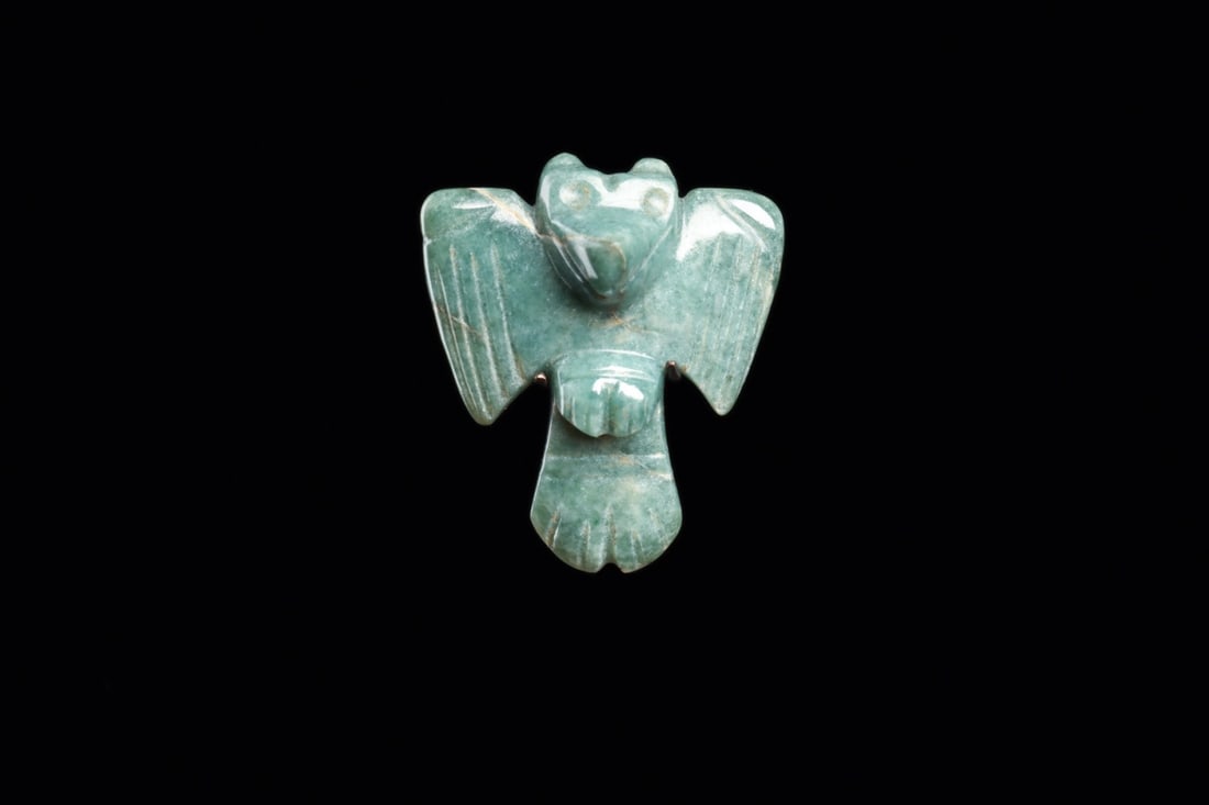 Costa Rican Jade Avian Pendant with Spread Wings, Ca. 500-1000 CE: Pre-Columbian, Costa Rica, ca. 500–1000 CE. A small raptor spreads its wings in blue-green jade, carved and polished to a soft luster with the pale veining of the stone left visible across one w