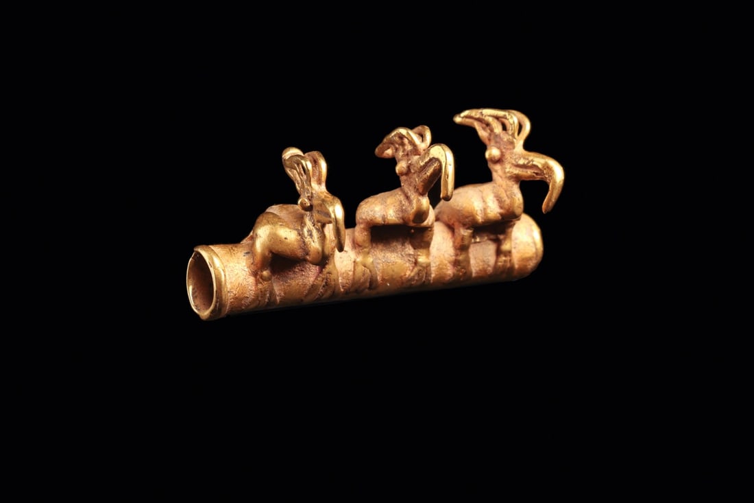 Cocle Gold Tubular Bead Pendant with Three Crested Birds: Pre-Columbian, Panama, Cocle, ca. 900–1100 CE. A heavy cast gold tube ridden by three birds in file, each perched with folded body, a bulbous eye, a great hooked beak and a swept, openwork crest