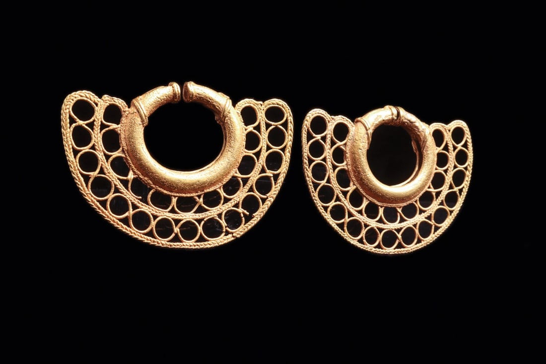 Sinu Large Gold Filigree Crescent Ear Ornaments, Pair: Pre-Columbian, Colombia, Sinu, ca. 1000–1250 CE. A matched pair of large crescentic ear ornaments in high-karat gold, each built from a solid tubular hoop that swells into a fan of openwork. Two