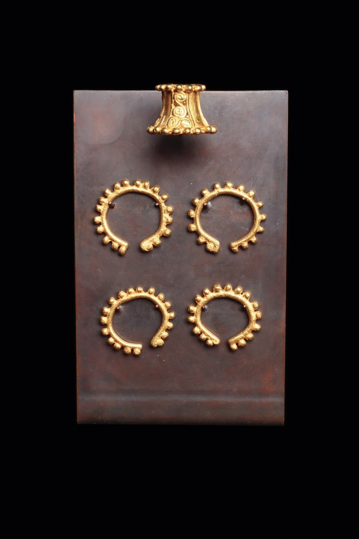 Quimbaya Gold Nose Ornaments, Group of Five, Mounted: Pre-Columbian, Colombia, Quimbaya, ca. 400–700 CE. A constellation of five cast gold nose ornaments, four of them a matched set of open crescent rings ringed with a beaded outer border of small 