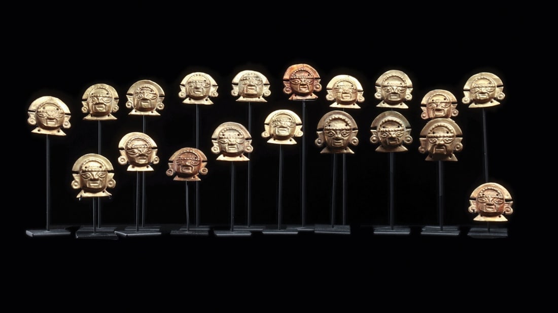 Lambayeque Sheet Gold Head Appliques, Group of 19 with Crescent Crowns: Pre-Columbian, Peru, North Coast, Lambayeque (Sican), ca. 800–1200 CE. A parade of nineteen miniature faces hammered from thin sheet gold, each raised in repousse into the same lordly countenanc