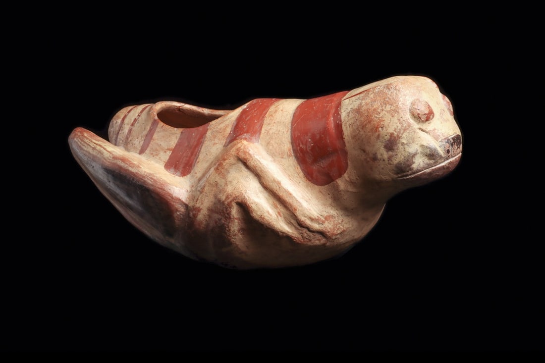 Moche Grasshopper Effigy Vessel with Red-on-Cream Slip: Pre-Columbian, Peru, Moche, ca. 500–800 CE. A grasshopper modeled in the round, its body swelling into a hollow chamber with a broad oval opening set into the back. The buff, cream-slipped earth