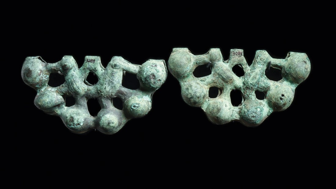 Loma Negra Bell Panels with Incised Hummingbirds, Pair: Pre-Columbian, Peru, Moche, Loma Negra, 100 CE. A matched pair of fan-shaped bell panels, each cast in copper with six globular chambers ranged in two tiers across an openwork frame. The interstices b