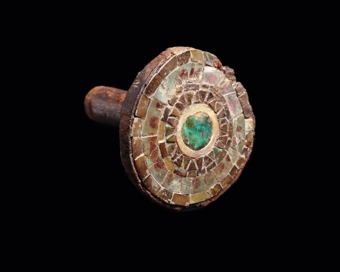 Moche Wood Ear Ornament with Turquoise and Shell Mosaic Disc: Pre-Columbian, Peru, Moche, ca. 100–300 CE. A carved hardwood ear ornament, its cylindrical insertion tang rising to a broad disc face laid with mosaic. Four concentric bands of cut stone and sh
