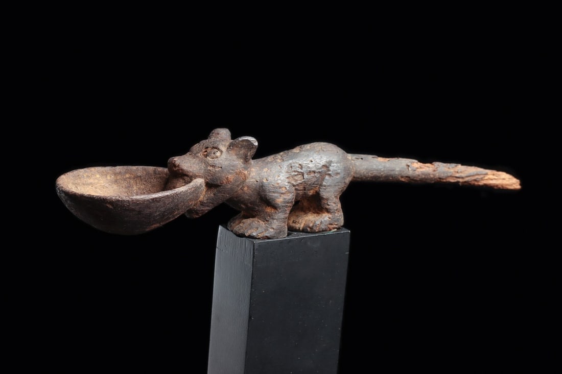 Moche Carved Wood Medicine Spoon with Standing Fox: Pre-Columbian, Peru, North Coast, Moche, ca. 100–500 CE. A fox stands watchful along the shaft of this small carved wood implement, its long tapering tail drawn out to serve as the handle and it