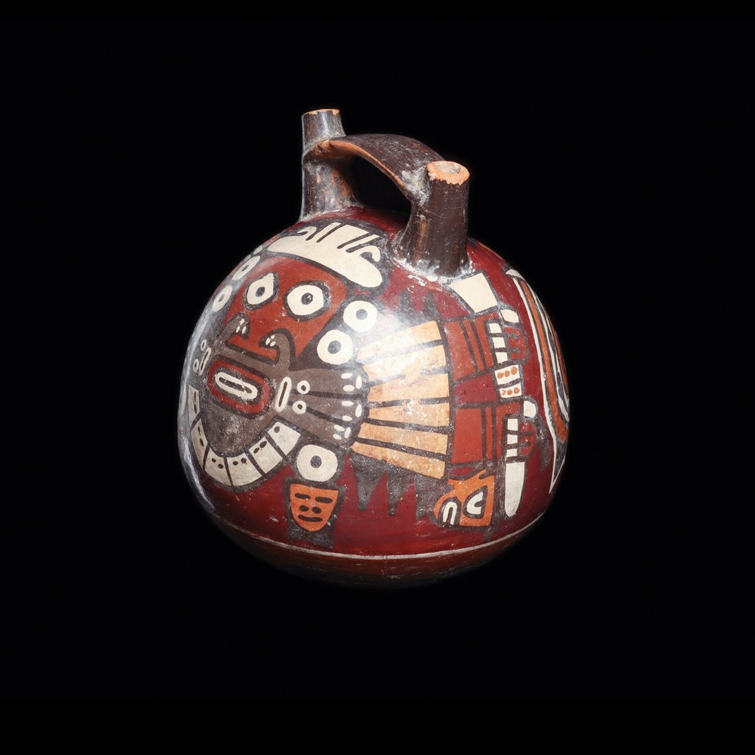 Nazca Double Spout Bridge Vessel with Trophy Head Warrior: Pre-Columbian, Peru, Nazca, ca. 100–600 CE. A globular ceramic vessel rising to twin tapered spouts joined by a flat strap bridge, its surface burnished and painted in slip polychrome of oxblood