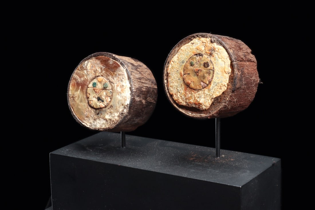 Chimu Wooden Ear Spools with Shell Mosaic Owl Faces, Pair: Pre-Columbian, Peru, North Coast, Chimu, 1000 CE. A matched pair of small carved hardwood ear spools, each cylindrical shaft opening into a broad disc face inlaid with mosaic. Set into each front is a