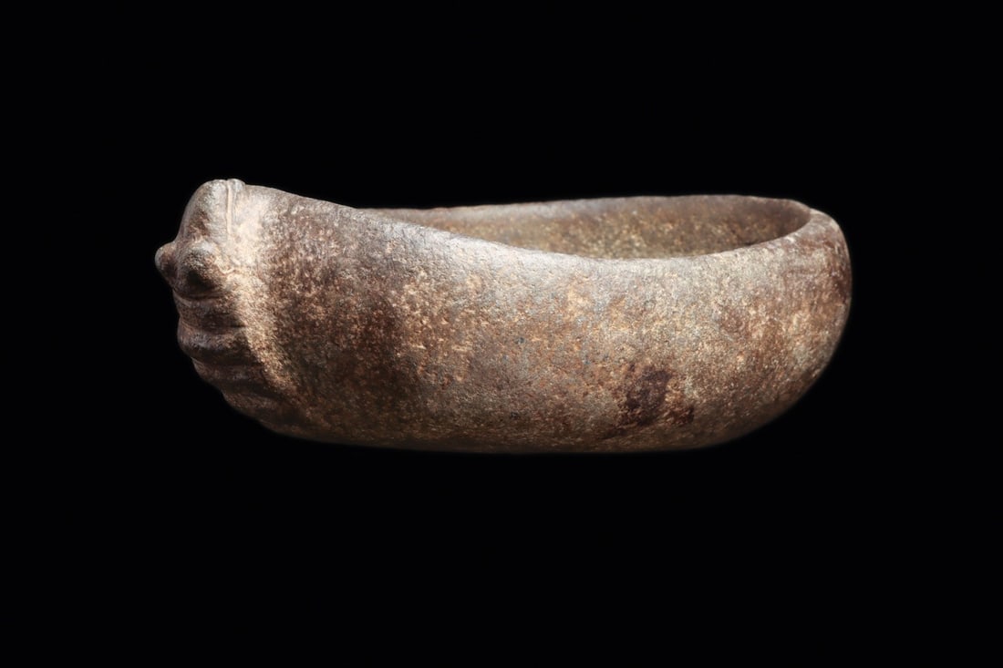 Condorhuasi Alamito Stone Armadillo Bowl, Argentina: Pre-Columbian, Argentina, Condorhuasi-Alamito, ca. 400 BCE – 250 CE. A dense gray-black stone bowl carved in the round as a resting armadillo, its thick walls hollowed to a shallow recessed rece