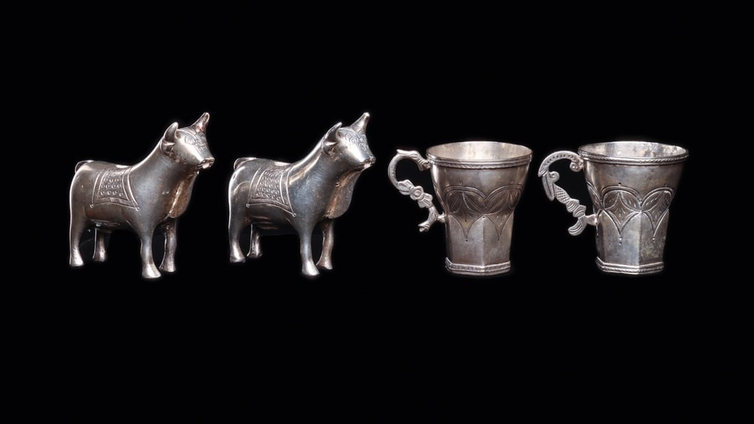 Bolivian Silver Torito Bull Vessels and Tassito Cups, 19th C. (4): South America, Bolivia, Colonial tradition, ca. 1800–1899 CE. A quartet of Andean festival silver: two solid cast bulls and two flaring sheet-silver beakers. The toritos stand four-square with c