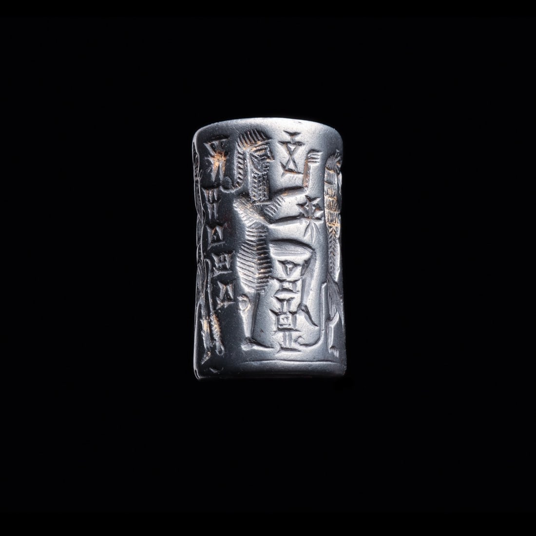 Akkadian Hematite Cylinder Seal with Contest Scene and Cuneiform Inscription: Near East, Mesopotamia, Akkadian, ca. 2350–2150 BCE. A dense contest scene wraps this polished black hematite cylinder, cut in crisp intaglio so that a single roll across damp clay yields a cont
