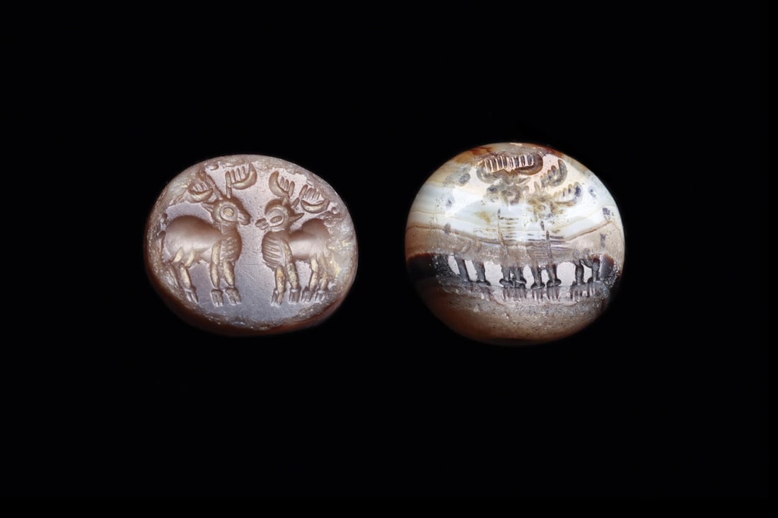 Sasanian Banded Agate Stamp Seals with Confronted Stags, Pair: Western Asia, Sasanian Empire, ca. 400–600 CE. A pair of dome-form stamp seals cut from banded agate, one warm brown and cream, the other layered in cream, amber and near-black strata. Each is d