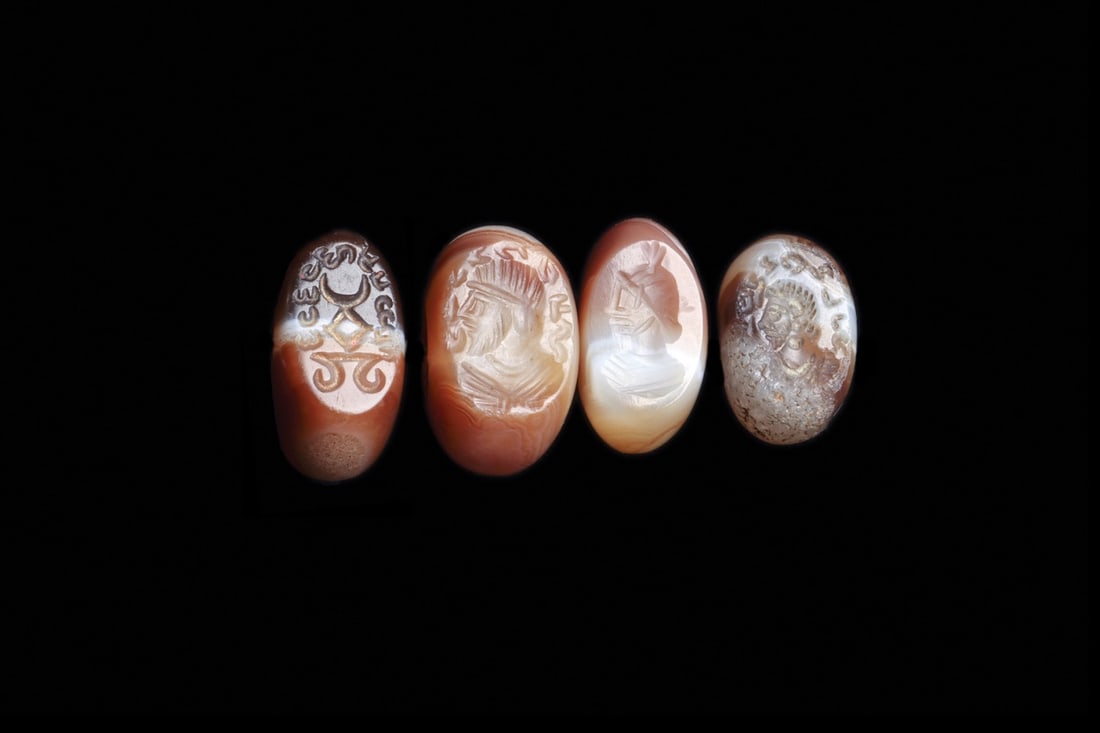 Sasanian Banded Agate Stamp Seals with Royal Busts, Group of 4: Western Asia, Persia, Sasanian Empire, ca. 400–600 CE. A quartet of domed banded agate sealstones, their brown and cream strata polished to a lustrous curve above flat engraved faces. Three carr