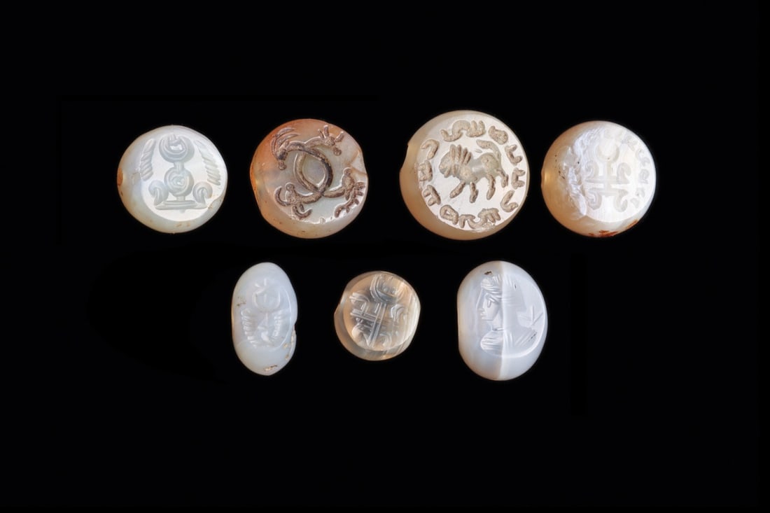 Sasanian Agate Stamp Seals, Group of Seven with Nishans, Lion and Bust: Western Asia, Sasanian Empire, ca. 400–600 CE. A group of seven small stamp seals cut from creamy white and faintly banded agate, most domed above a flat engraved face, one or two of flattened o