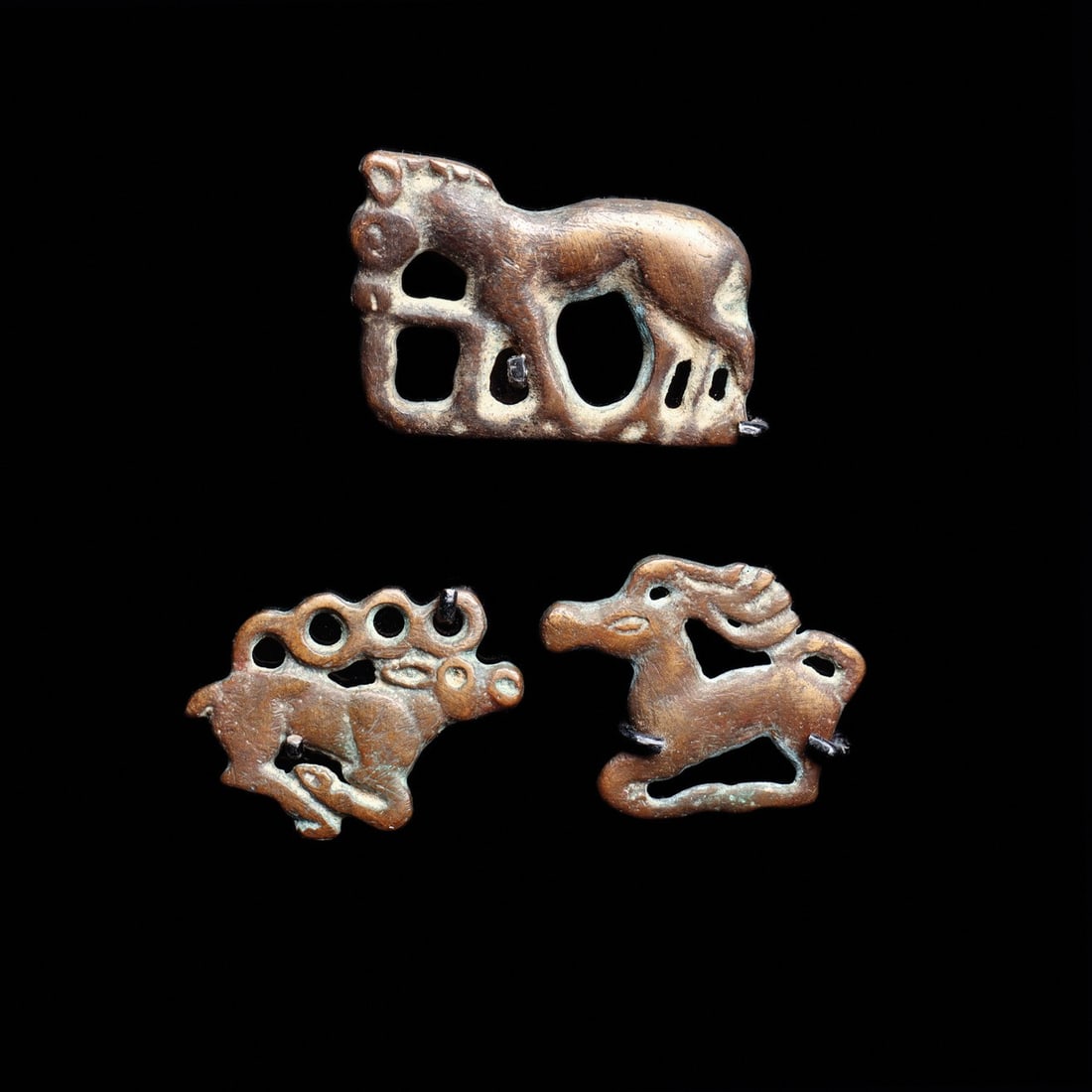 Ordos Animal Style Appliques, Horse and Stags, Group of Three: Eurasia, Persia to Central Asian Steppes, Ordos culture, ca. 500–100 BCE. A trio of small cast openwork appliques rendered in the animal style of the Eurasian steppe: a standing horse with a bea