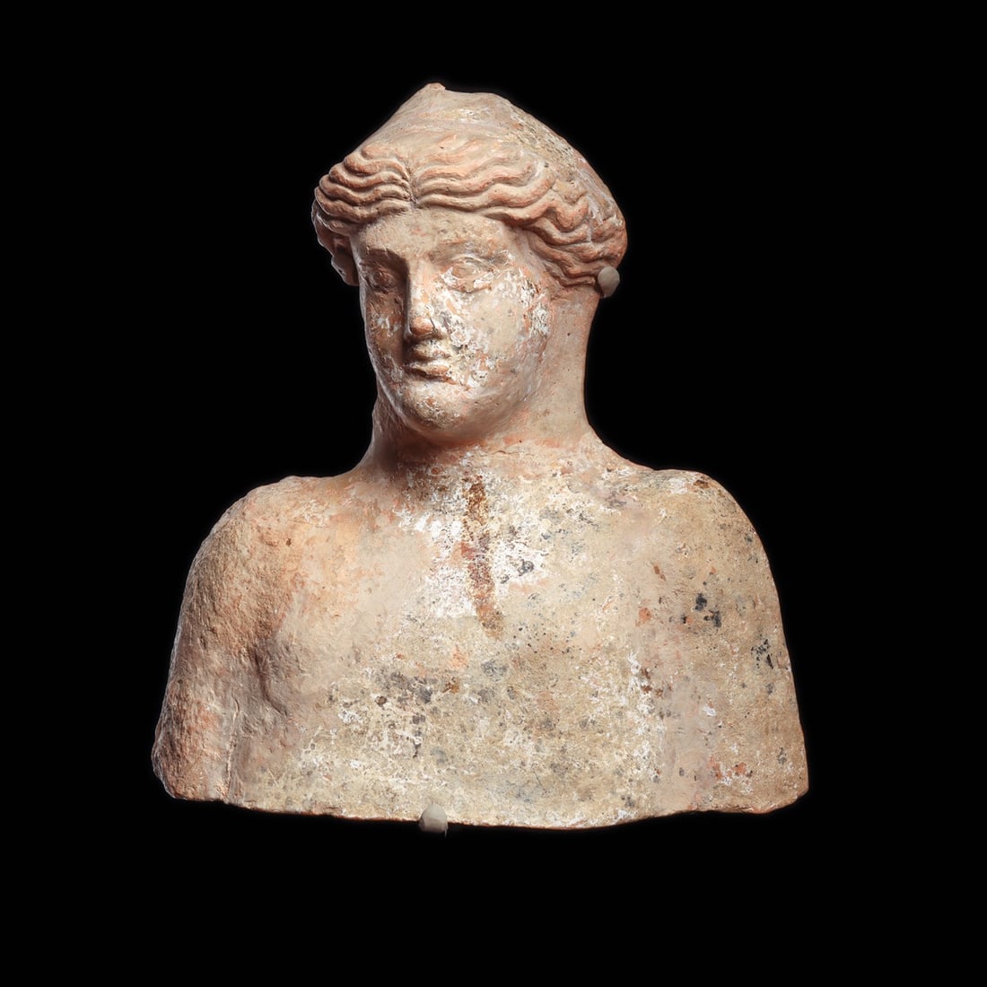 Magna Graecia Terracotta Bust of a Goddess, Likely Demeter or Persephone, 4th C. BCE: Southern Italy, Magna Graecia, Greek, ca. 400–300 BCE. A mold-made bust of a young woman in buff terracotta, her head inclined and her mouth curved in the last echo of the Archaic smile. The wav