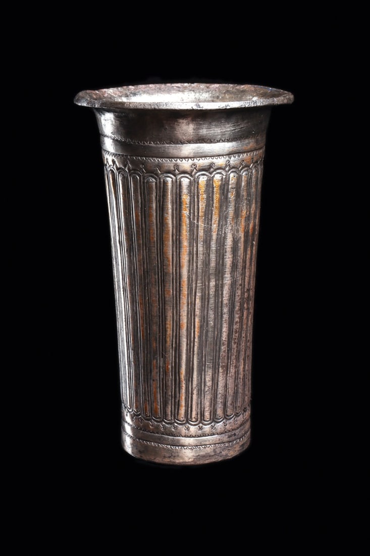Achaemenid Fluted Silver Beaker with Flared Rim: Near East, Persia, Achaemenid Empire, ca. 333–300 BCE. A tapered cylindrical beaker raised in sheet silver, its body worked in close vertical fluting that rises from a beaded groundline to a reg