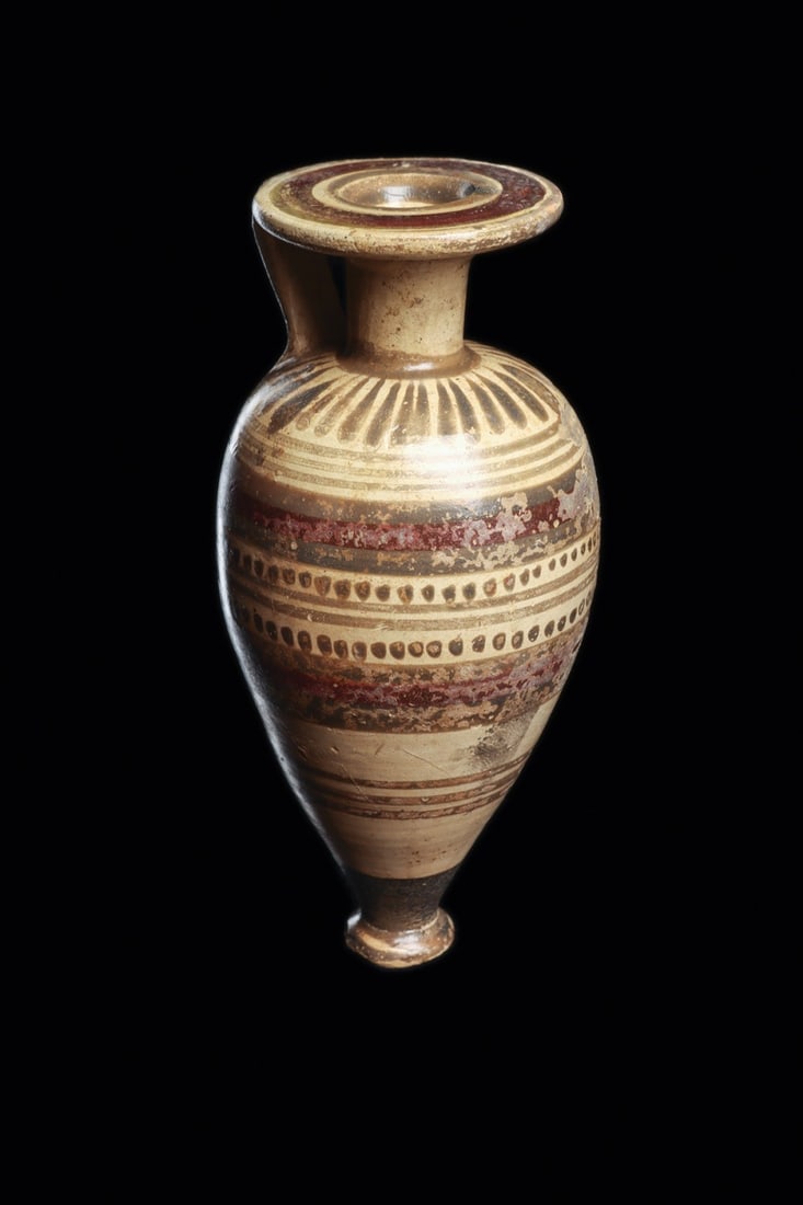 Etrusco-Corinthian Banded Amphoriskos, 7th-5th C. BCE Perfume Vessel: Italy, Etruria, Etrusco-Corinthian, ca. 700–400 BCE. A small piriform perfume flask, wheel-thrown in pale buff clay and turned on a disc foot, its long neck flaring into a broad flat-topped rim 