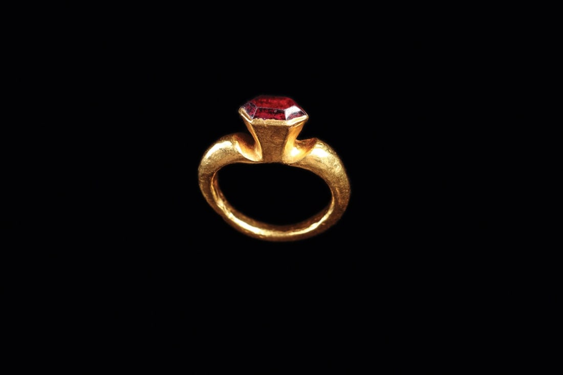 Islamic Gold Ring with Faceted Garnet, 9th-10th C.: Middle East, Early Islamic period, ca. 800–1000 CE. A single red flare of garnet crowns this gold finger ring, cut as a faceted lozenge and held in a tall tapering box bezel. The rounded shank s