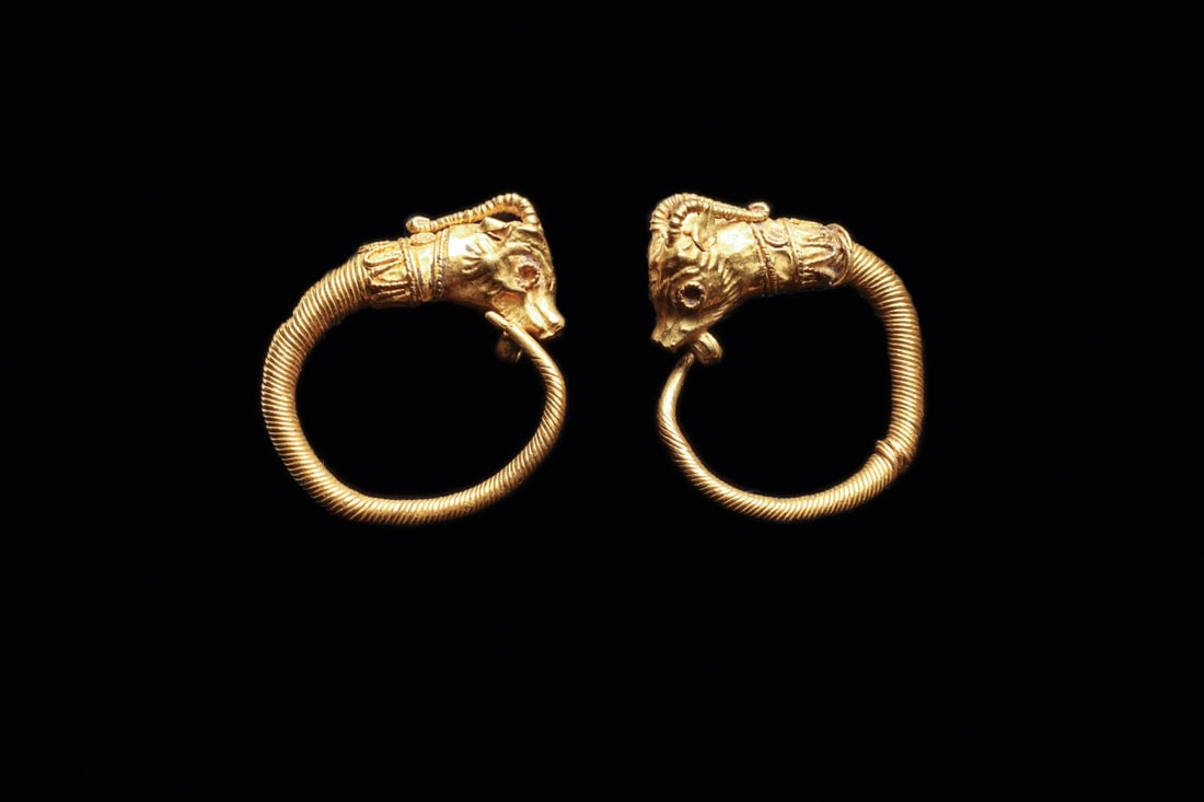 Hellenistic Greek Gold Hoop Earrings with Antelope Head Termini, 3rd-2nd C. BCE: Magna Graecia, Greek, Hellenistic period, ca. 300–100 BCE. A matched pair of gold hoops, each drawn from tightly coiled wire that swells from a slender tail into a modeled animal head. The termi
