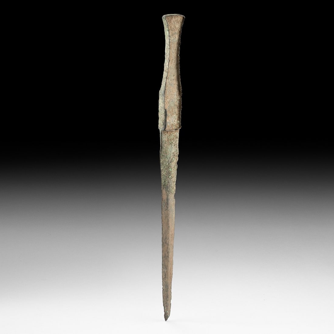 Near Eastern Luristan Bronze Blade, Zagros Highlands: Ancient Near East, Western Persia, Luristan, ca. 1200–800 BCE. A cast-bronze dagger with a tapering blade rising from a ribbed midsection to a flanged hilt and open pommel. The surface carries e