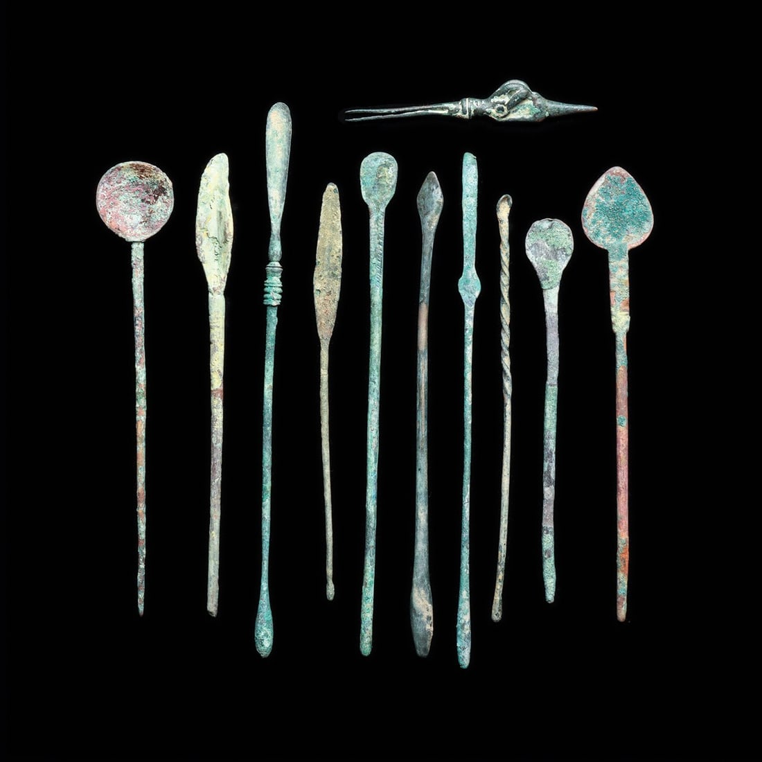 Roman Medical and Cosmetic Implements, Group of 11 with Luristan Tweezers: Eastern Mediterranean to Near East, Roman and Luristan, ca. 1–200 CE. A physician's working kit in miniature: ten slender cast implements, their shafts drawn to spatulate, olivary, and discoid t