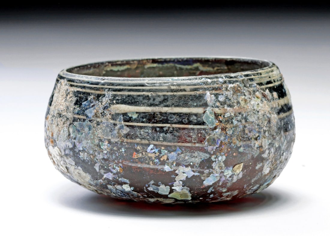 Roman Aubergine Glass Bowl: Ca. 100 BCE – 100 CE. Roman, ca. late 1st century BCE to 1st century CE. Deep hemispherical bowl of aubergine glass, a manganese-purple so saturated it reads nearly black except where thin at th