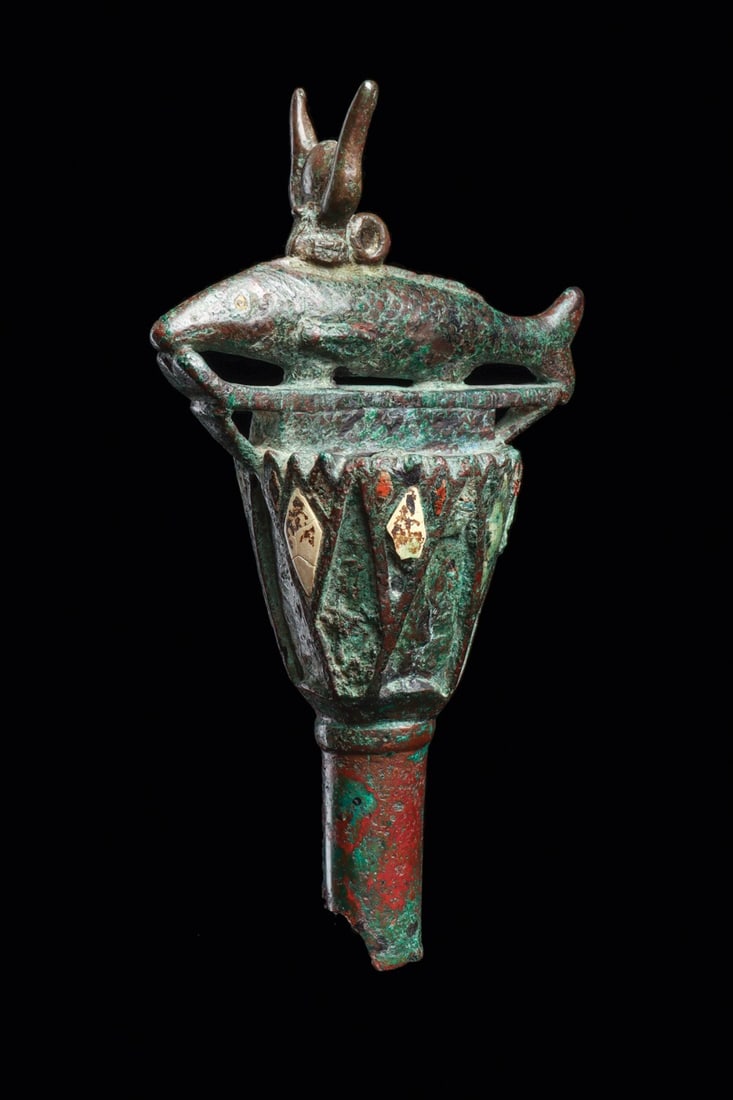 Egyptian Oxyrhynchus Fish Scepter Finial with Lotus and Inlays: North Africa, Egypt, Late Period to Ptolemaic period, ca. 712–30 BCE. A heavy cast finial from the upper end of a scepter, crowned by an oxyrhynchus fish wearing a uraeus diadem and poised above