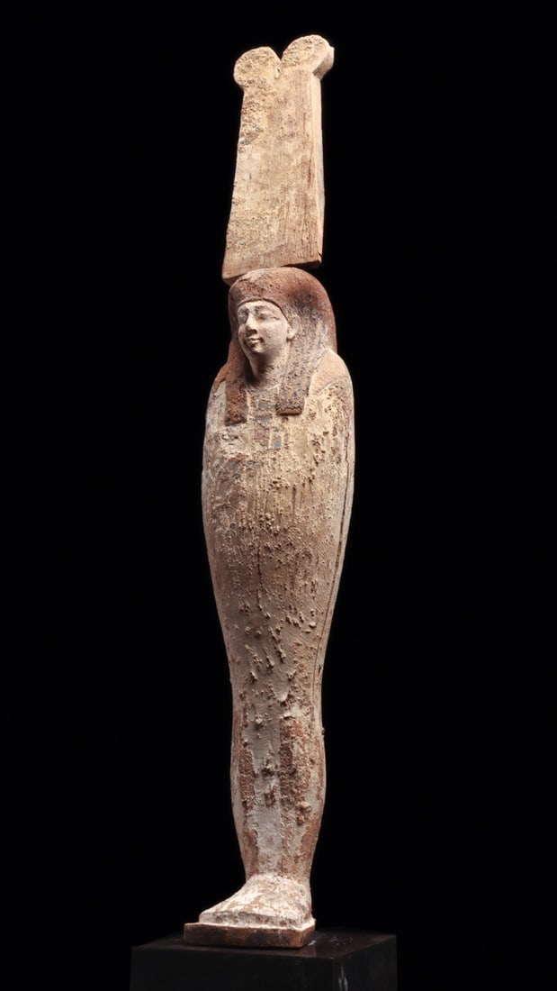 Egyptian Late Period Ptah-Sokar-Osiris Mummiform Figure with Plumed Crown: Egypt, Late Period, 525 BCE. A tall mummiform god in carved hardwood, standing rigid and shroud-wrapped upon an integral plinth. The face is finely cut, calm and full-lipped beneath a heavy tripartite