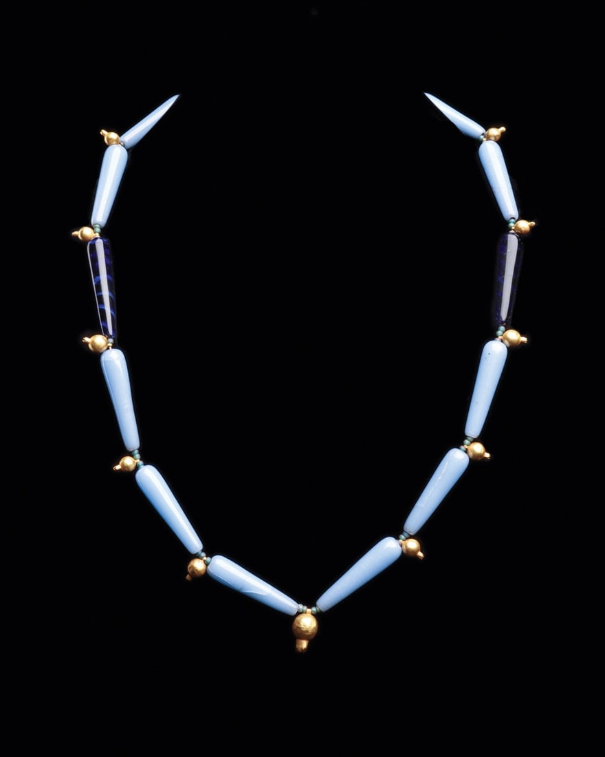 Amarna Period Glass and Gold Pomegranate Bead Necklace, 18th Dynasty: Egypt, New Kingdom, 18th Dynasty, Amarna period, ca. 1353–1336 BCE. A single strand of ten powder-blue elliptical glass beads punctuated by two deep midnight-blue examples, the darker pair marbl