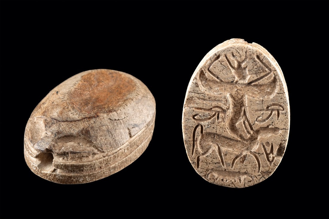 Phoenician Steatite Scarab with Winged Deity, ex-Mitry: Eastern Mediterranean, Phoenician, ca. 800–400 BCE. A steatite scarab carved, the base engraved with a winged figure in profile, seated on a long-snouted animal with one hand placed at its neck.