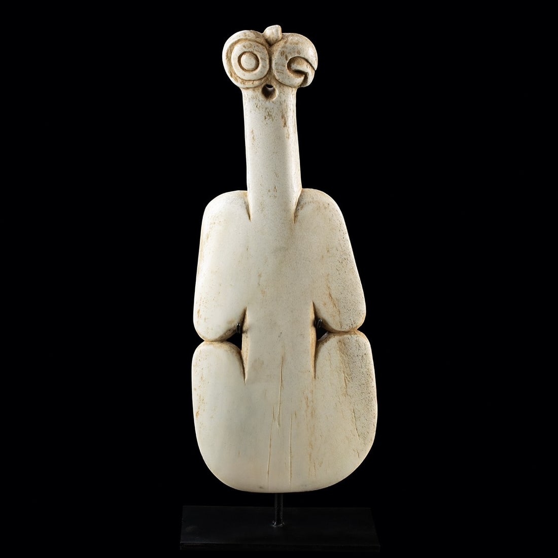 Maori Whalebone Kotiate Parāoa, Tiki Finial: Oceania, New Zealand, Maori, ca. early to mid 20th century CE. A carved whalebone kotiate parāoa, with a flattened bilobed blade of fiddle form, notched to each side, rising to a slender shaft to