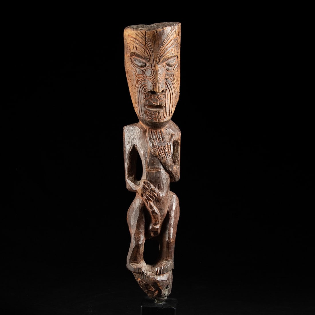 Maori Tekoteko Ancestral Figure, ca. 1850–1920: Oceania, New Zealand, Maori, ca. 1850–1920 CE. A tekoteko ancestral figure carved from a single length of hardwood, standing frontally at scale. The head is oversized in proportion to the body, 