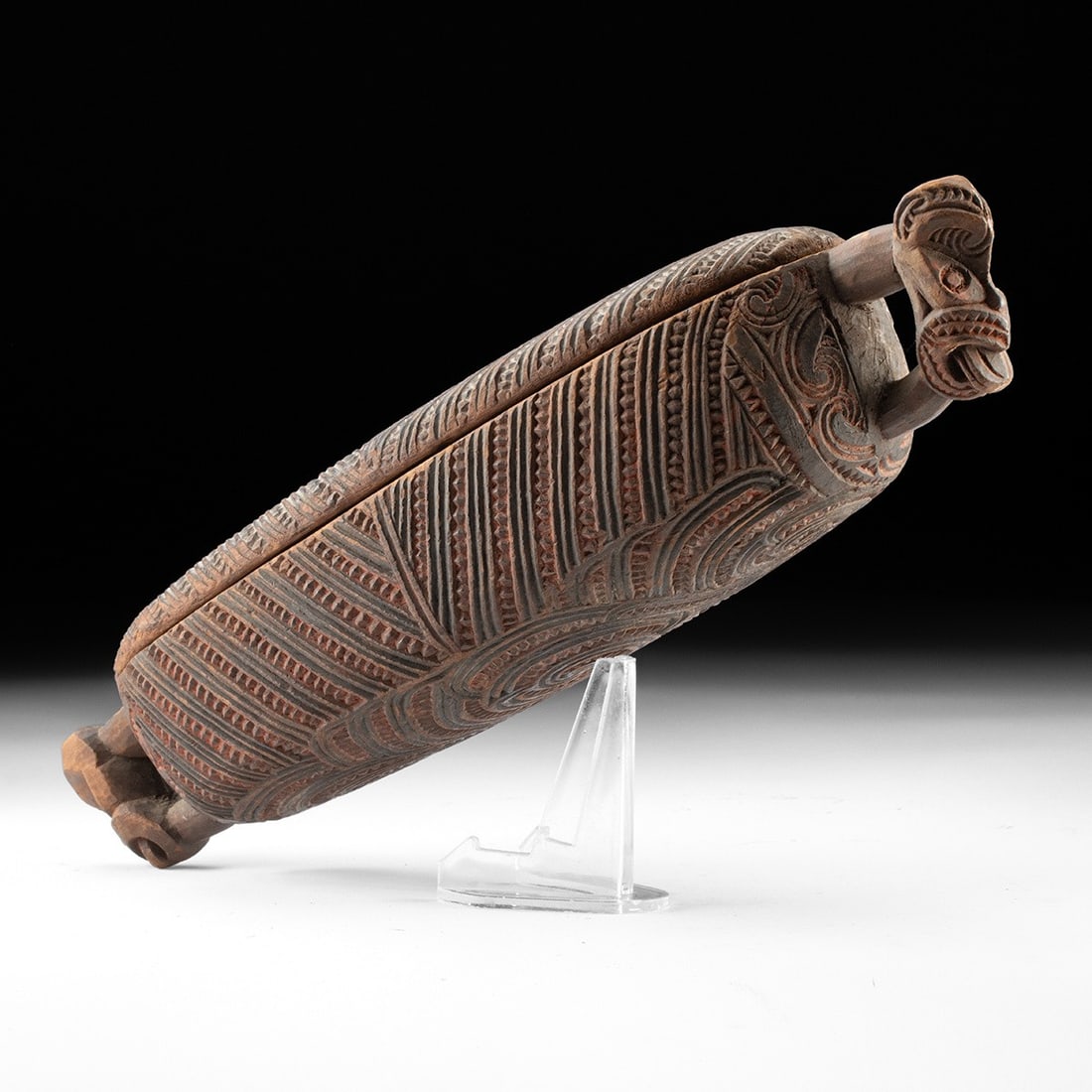 19th C. Maori Waka Huia Treasure Box, Carved Tiki Figures: Oceania, New Zealand, Maori culture, ca. 19th century CE. A lidded treasure box, or waka huia, of elongated, canoe-like form, the rounded body carved in low relief. The domed lid and underside carry p