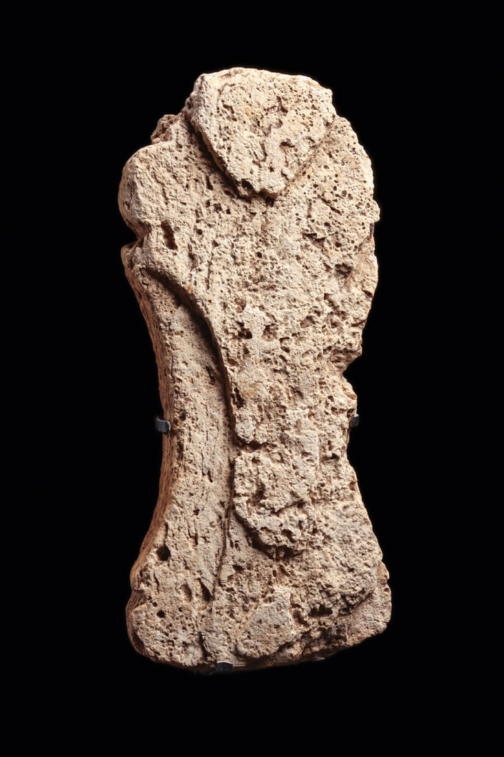 Sulawesi Coral Stone Ancestor Figure, Abstracted Idol on Custom Stand: Southeast Asia, Indonesia, Sulawesi Island, ca. 1400–1900 CE. A human presence pared down to its barest signals: a triangular face set in low relief above a tapering, plank-like torso. The figur