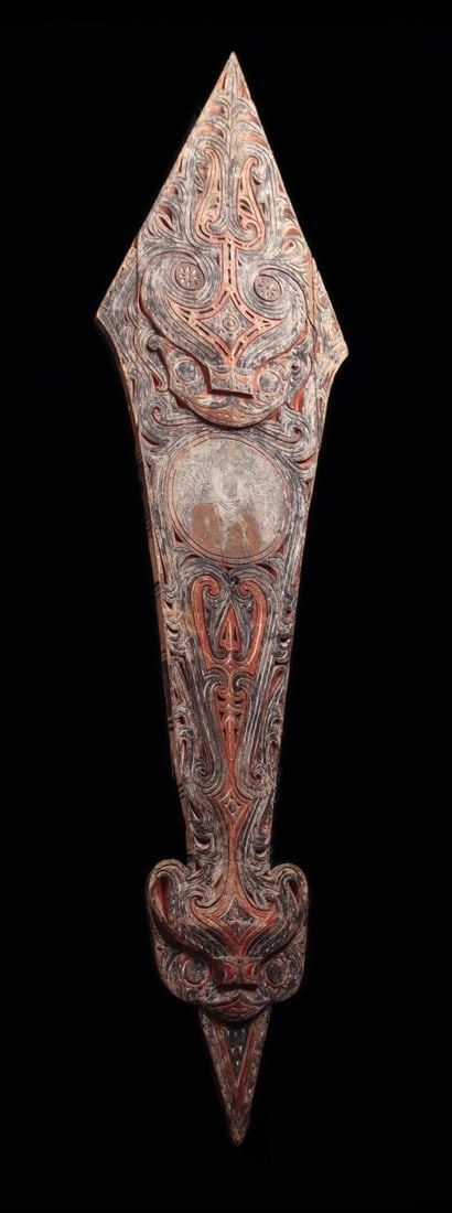 Toba Batak Pandilati Gable Ornament with Buffalo Heads and Portrait Medallion: Southeast Asia, Sumatra, Indonesia, Toba Batak, ca. 1870–1930 CE. A towering arrow-form architectural panel of carved and painted wood, its surface worked in dense low relief with scrolling tend