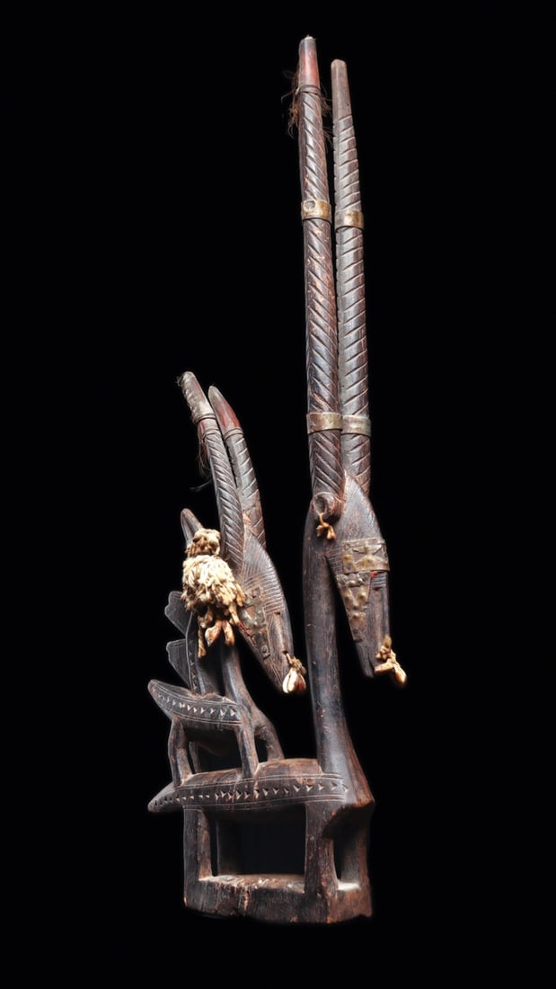 Bamana Chiwara Female Antelope Maternity Crest Headdress with Cowries: West Africa, Mali, Bamana culture, ca. 1800–1950 CE. A carved wooden crest headdress of the vertical Chiwara type, presenting a female roan antelope with her fawn perched upon her back. Both ani