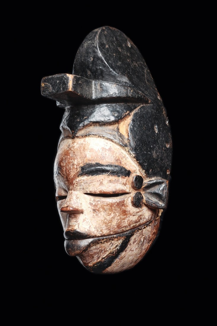 Ogoni Elu Mask with Articulated Jaw and Crested Headdress, Nigeria: West Africa, Nigeria, Niger Delta, Ogoni peoples, ca. 1880–1960 CE. A small wooden face mask whose lower jaw swings free on cord hinges, carved with a thick crest surmounted by a projecting tab 