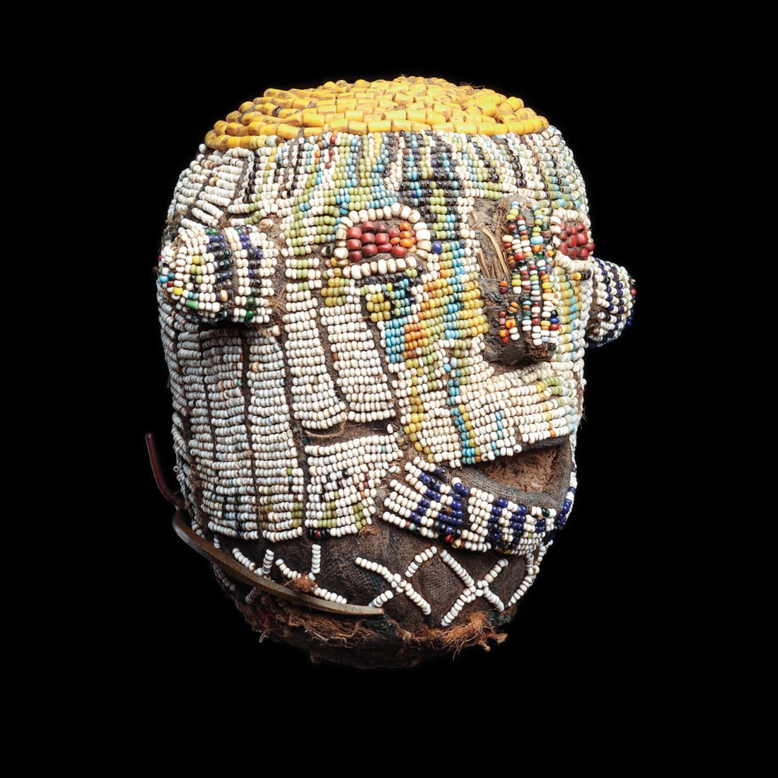 Bamun Beaded Trophy Head "Atwonzen", Cameroon Grassfields: Africa, Cameroon, Grassfields, Bamun peoples, ca. 1880–1950 CE. A human head sheathed entirely in imported glass seed beads, each one stitched in tight rows over a cloth-covered carved wooden co