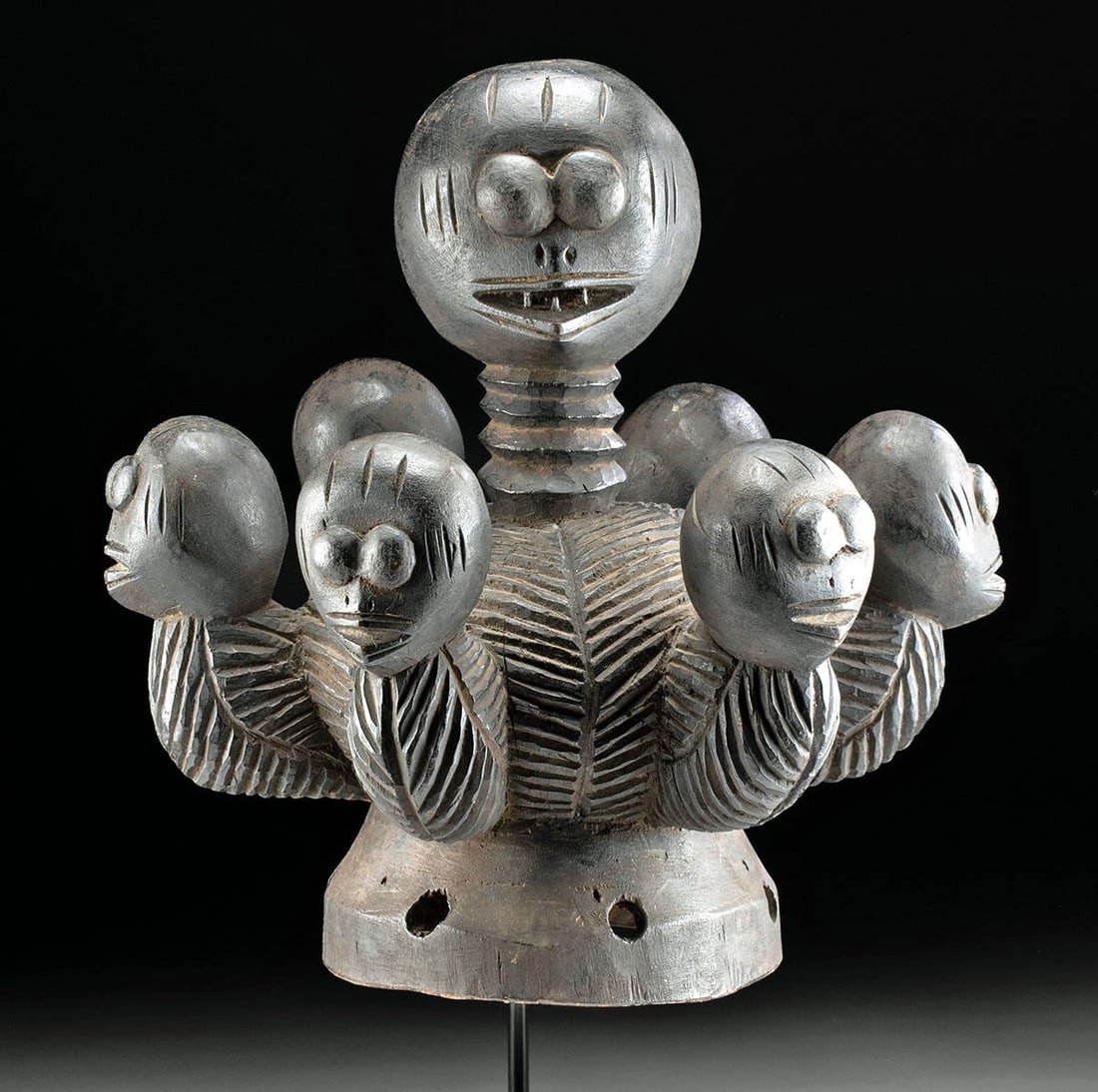 Ibibio Wooden Dance Crest with Seven Heads, Nigeria: Ca. 1900–2000 CE. West Africa, Nigeria, Ibibio people, ca. 20th century CE. A wooden dance crest comprised of a helmet-shaped calotte with a central projecting head, surrounded by six additional