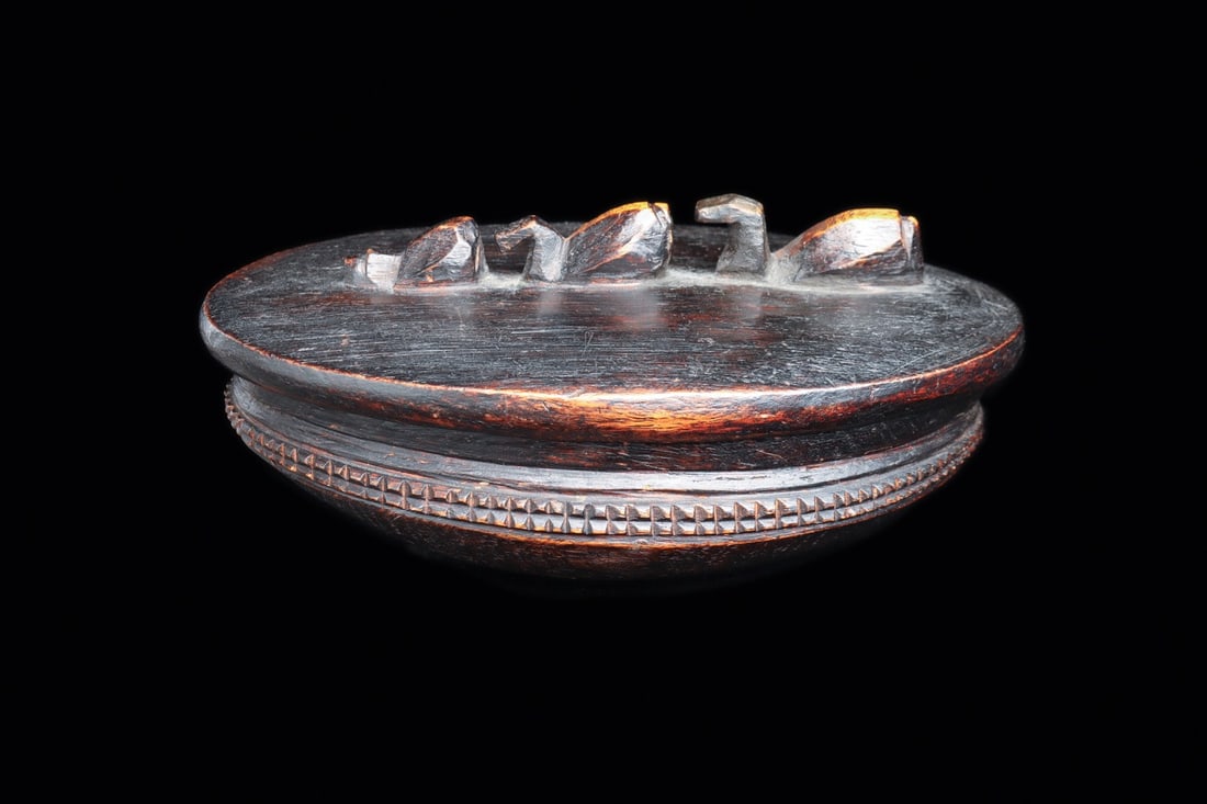 Lozi Lidded Wood Bowl with Water Birds, Zambia, Early 20th C.: Africa, Zambia, Lozi (Barotse) peoples, ca. 1900–1960 CE. A carved hardwood bowl of shallow ovoid form with rounded base, closed by a fitted lid whose crest carries three water birds filing down