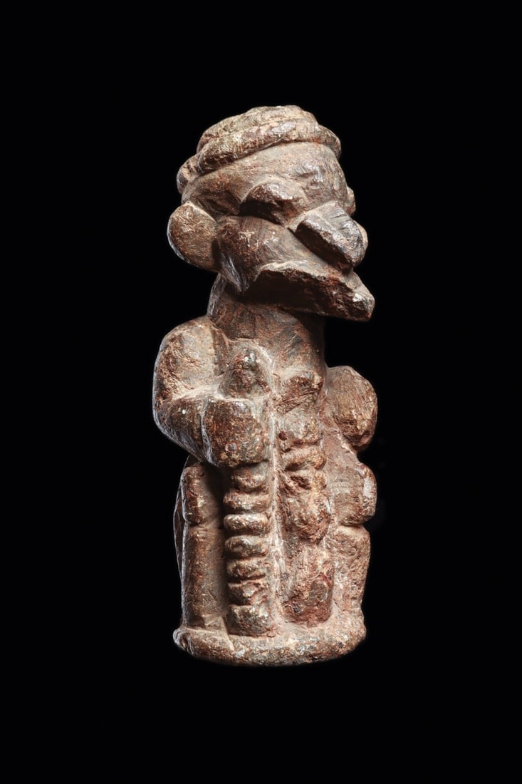 Kissi Steatite Pomdo Warrior Figure with Shield and Staff: West Africa, Sierra Leone, Kissi or earlier Sapi culture, ca. 1000–1500 CE. A compact steatite warrior stands with a staff or short sword raised in one hand and a domed shield gripped in the oth
