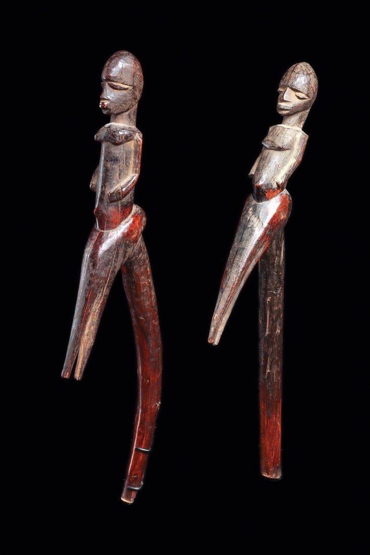 Lobi Figural Staff Finials, Pair, Burkina Faso, Early to Mid 20th C.: West Africa, Burkina Faso, Lobi peoples, ca. 1900–1960 CE. A pair of slender angular hardwood staffs, each carved from a single branch and surmounted by an abstract anthropomorphic figure rising