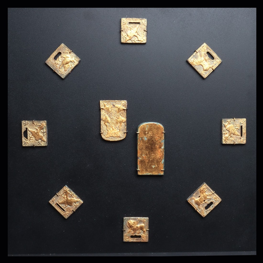 Tang Dynasty Gilded Belt Plaque Assembly with Birds and Beasts, 8th C.: East Asia, China, Tang Dynasty, 700 CE. A complete belt garniture of ten gilded plaques, each cast in low relief and set against a finely punched ring-matted ground that throws the figures forward. Ei