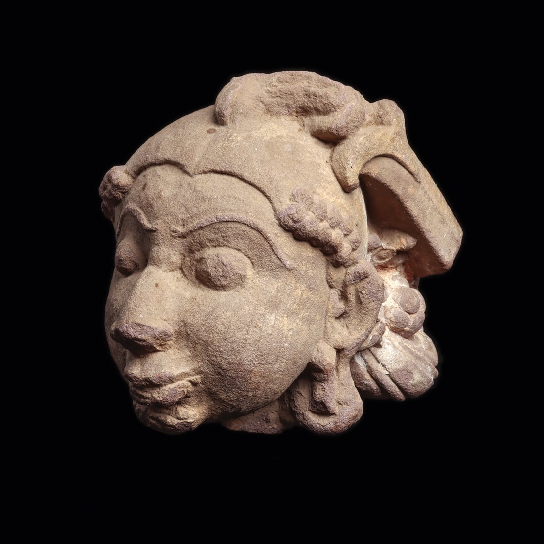 Rajasthan Sandstone Head of a Celestial Being, 11th-15th C.: South Asia, Northern India, Rajasthan or Madhya Pradesh, ca. 1000–1500 CE. A serene face emerges from buff sandstone, broken from the body of a once life-size temple figure. The carver gave him 