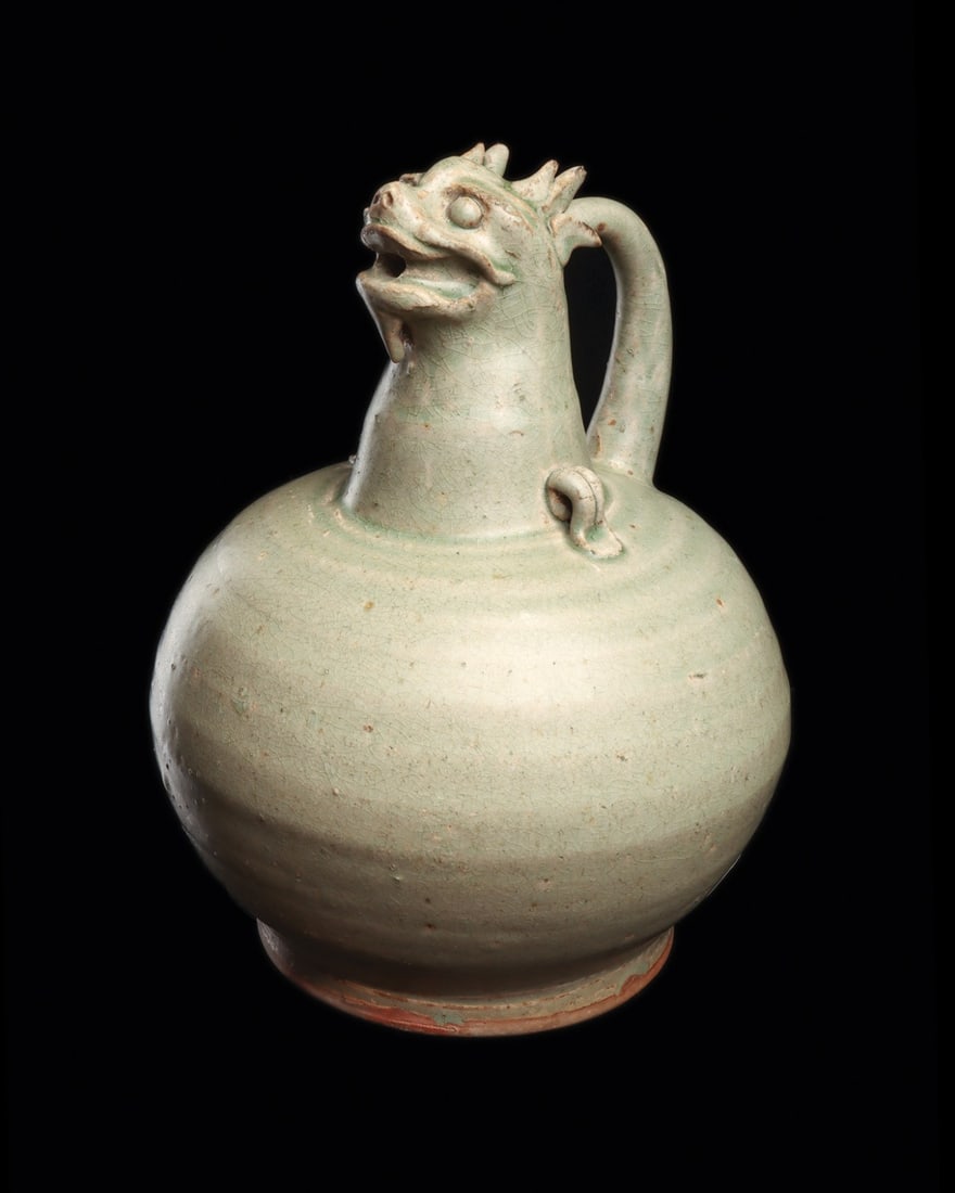 Korean Celadon Dragon-Head Ewer with Loop Lugs: East Asia, Korea, Joseon Dynasty, ca. 1300–1600 CE. A globular ewer rises to a tall neck crowned by a modeled dragon head, its jaws parted so the open mouth serves as the pouring aperture. Horne