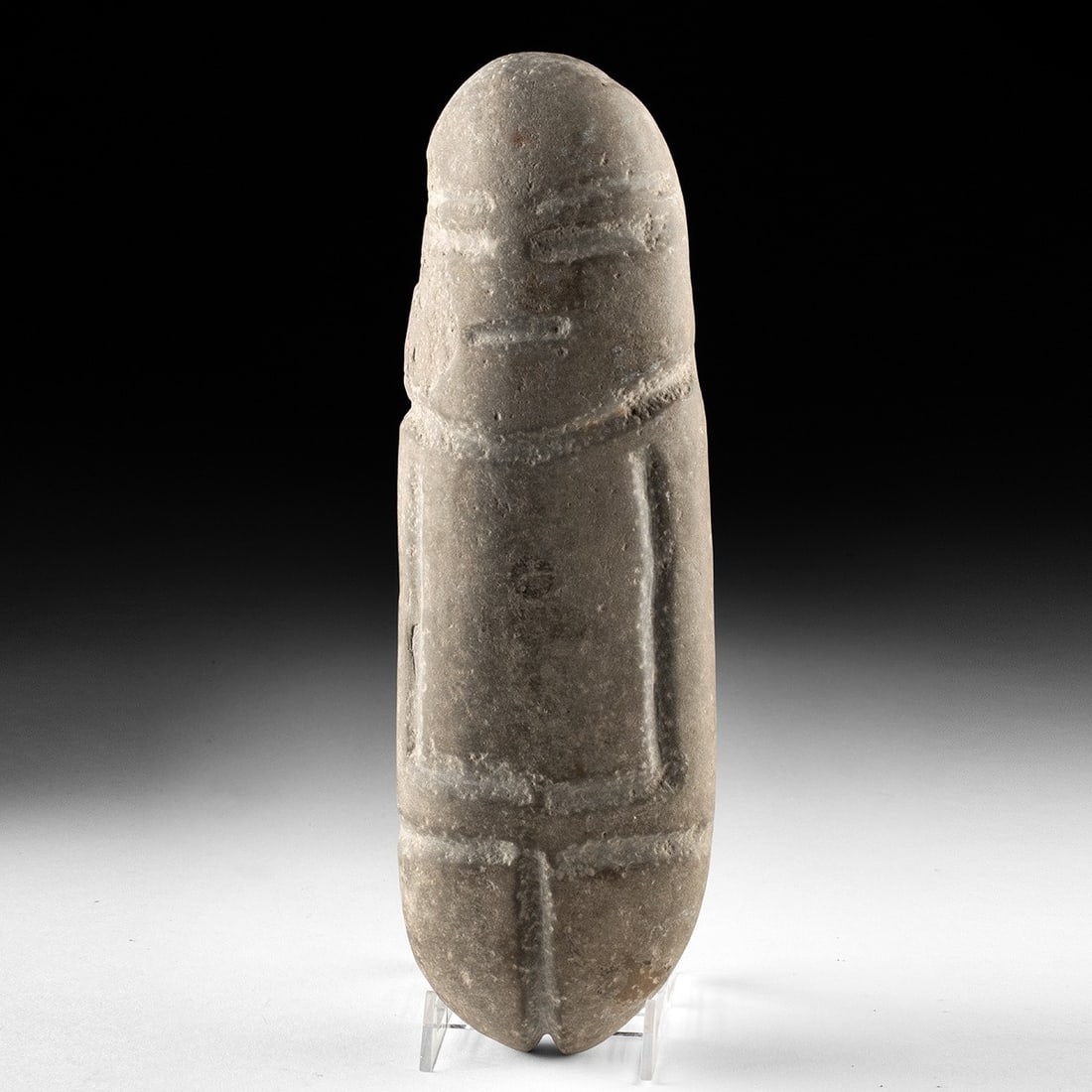 Large Guerrero Mezcala Stone Axe God Figure: Pre-Columbian, Mexico, Guerrero, Mezcala, ca. 700 BCE – 200 CE. A tall pebble of grey volcanic stone reduced, by patient abrasion, to the essential idea of a human being. The Mezcala lapidary wo