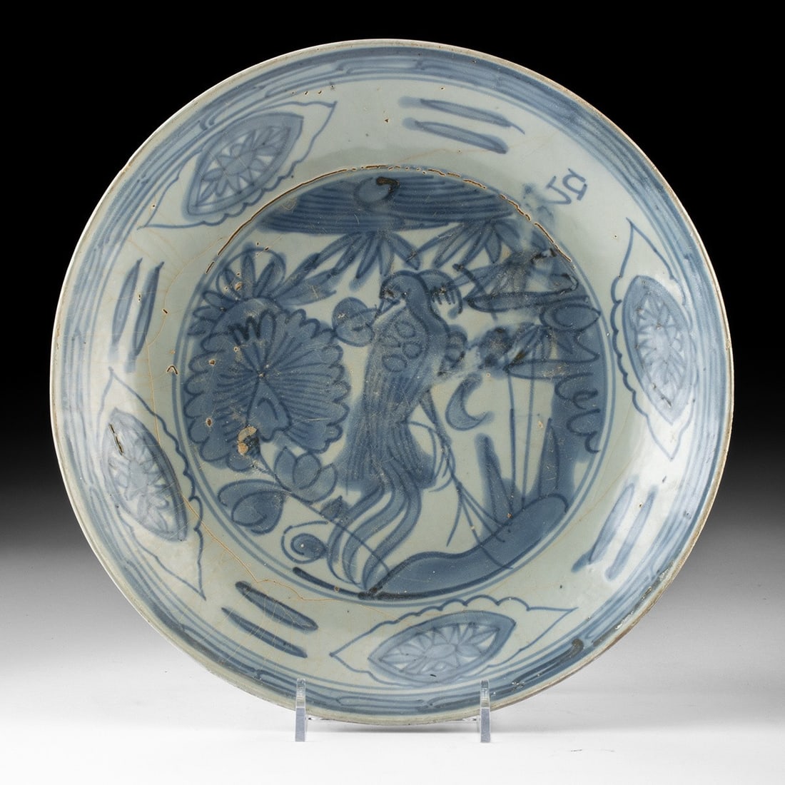 Ming Zhangzhou Blue & White Dish, Phoenix and Peony: East Asia, China, Ming Dynasty, ca. 1550–1644 CE. A broad, shallow porcelain dish painted in cobalt beneath a thick, greyish glaze, its interior given over to a spirited bird among flowering peo