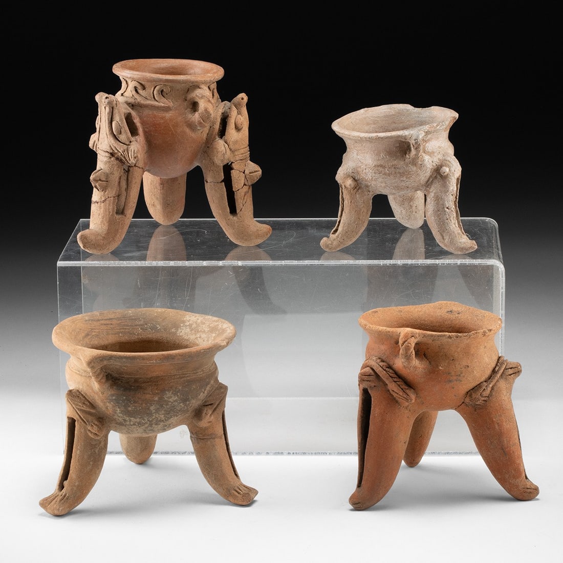 4 Costa Rican Tripod Rattle Vessels w/ Zoomorphic Legs: Pre-Columbian, Costa Rica, ca. 300–1200 CE. A quartet of buff-to-orange earthenware bowls, each raised on three hollow, slipper-shaped supports whose interiors hold loose clay pellets, so that l